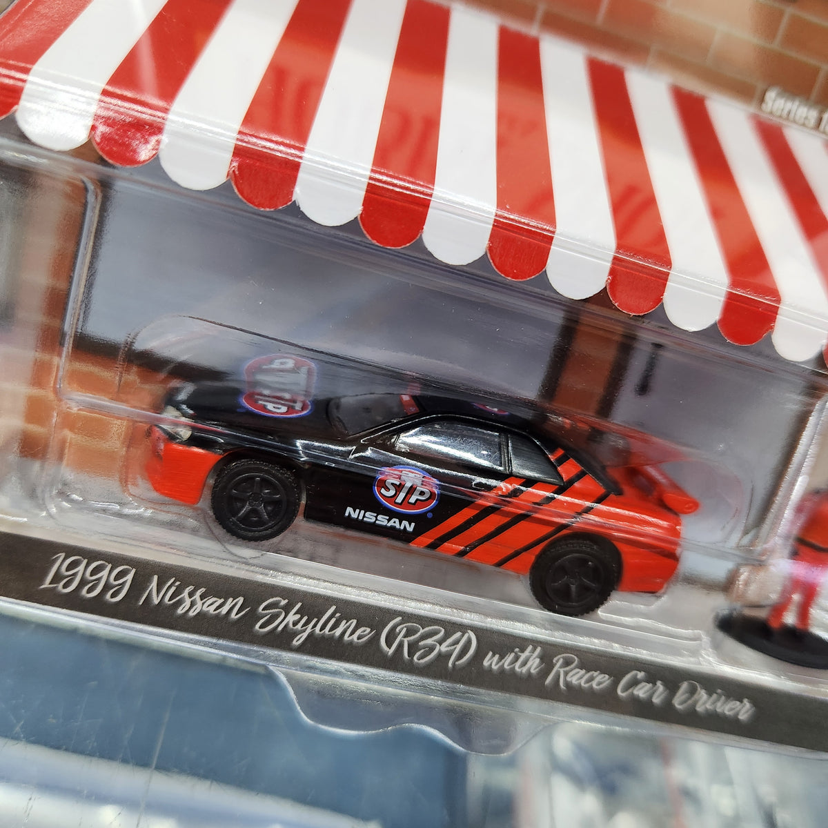 Greenlight - The Hobby Shop Series 13 - 1999 Nissan Skyline (R34) with Race Car Driver